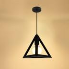 Black pendant light with a warm glow on a beige background