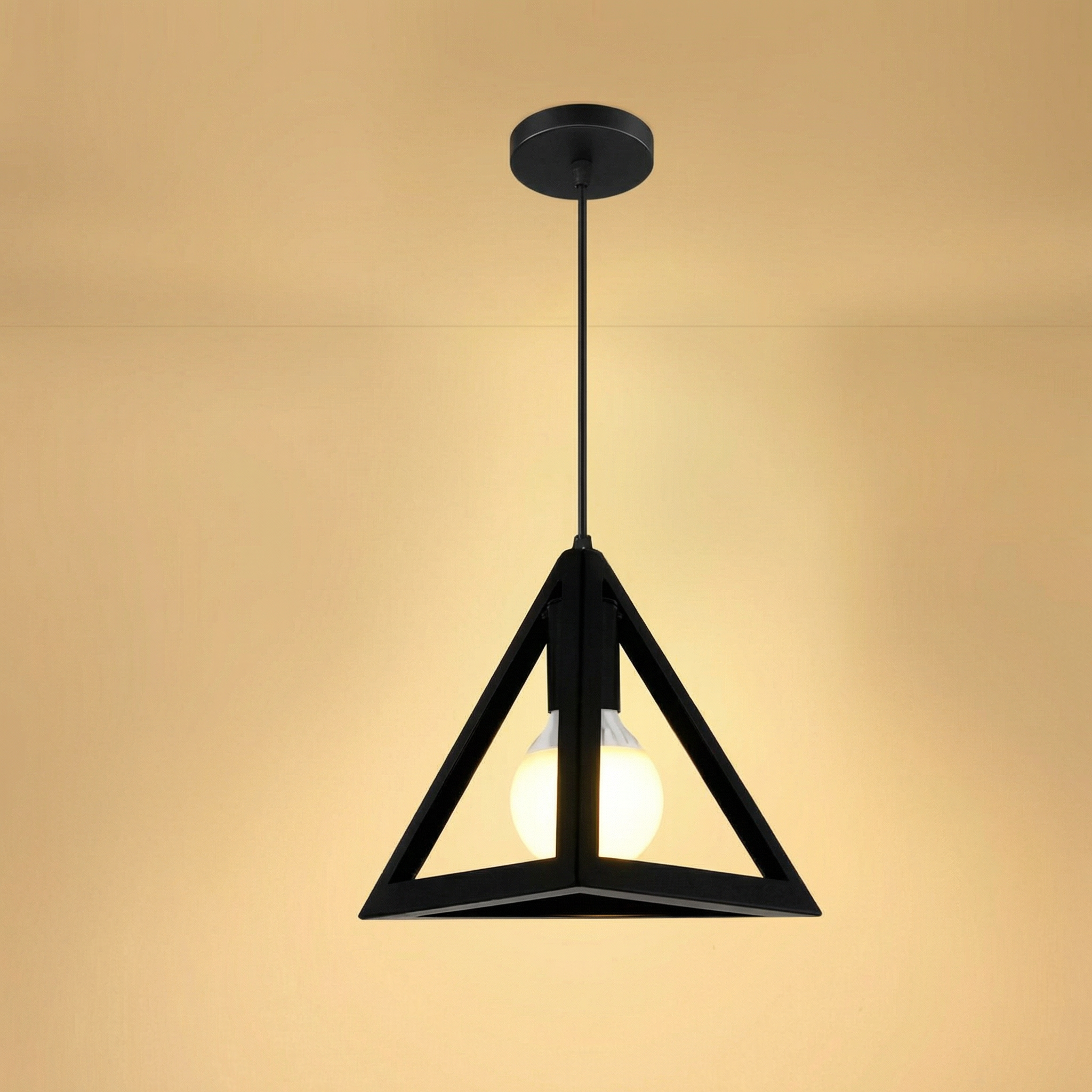 Black pendant light with a warm glow on a beige background
