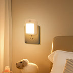 Night light attached to a wall near a bed with a plush toy sheep in the foreground.