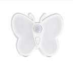 A white butterfly-shaped motion sensor night light with a central circular sensor and a small button marked with an 'M', shown on a plain white background.