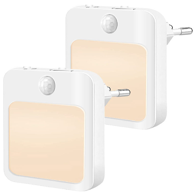 Two white motion sensor lights with beige panels on a white background