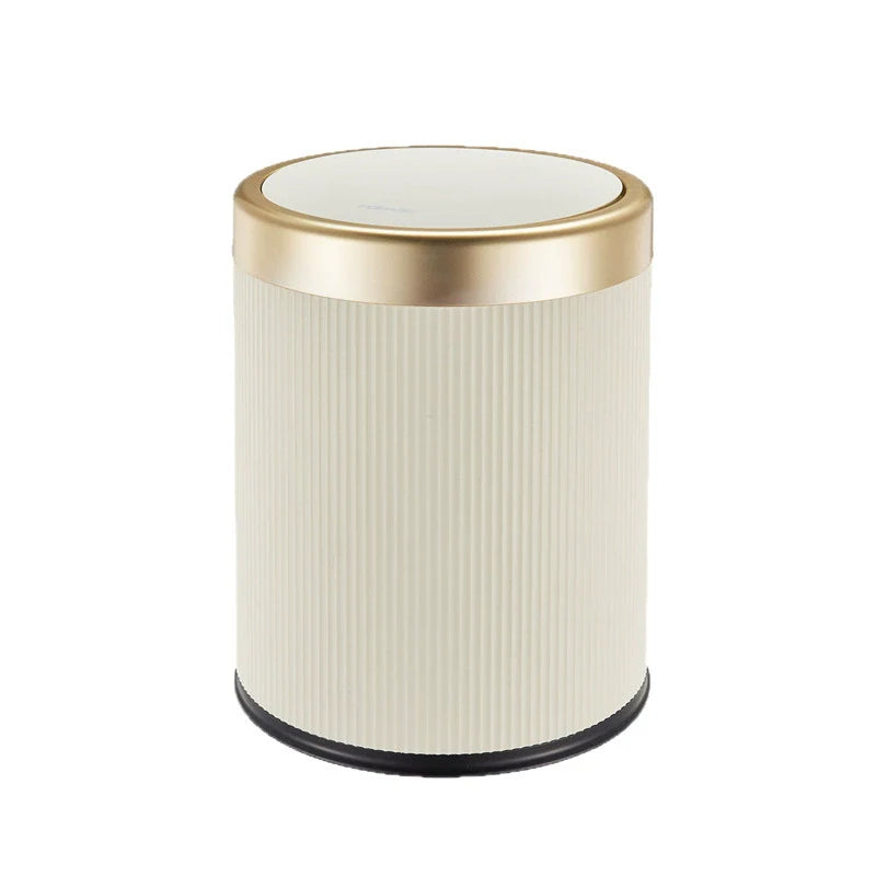 Round trash can with ribbed design and gold rim on a white background
