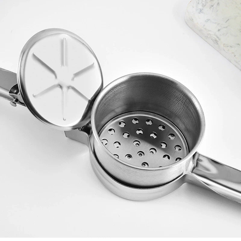 Metallic kitchen tool with a perforated lid on a light background