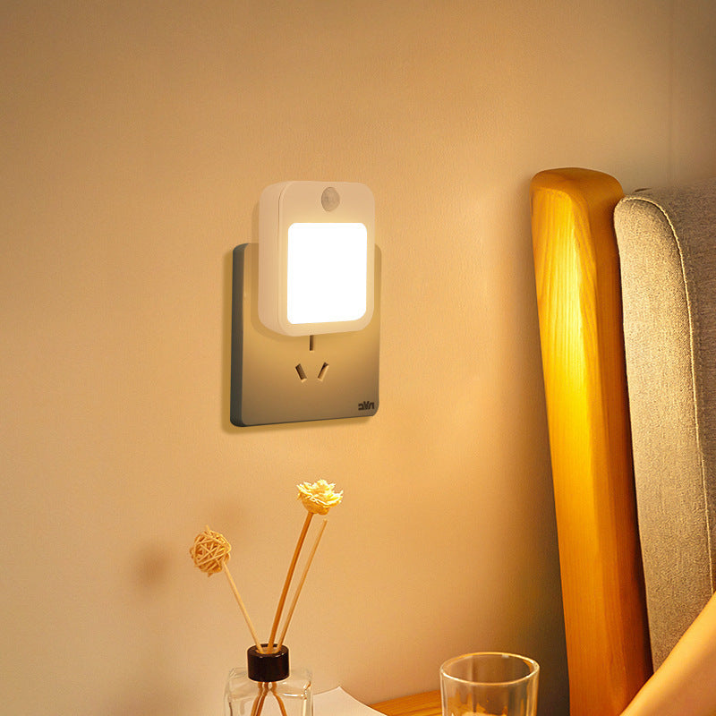 Wall-mounted night light emitting a warm glow in a bedroom setting.