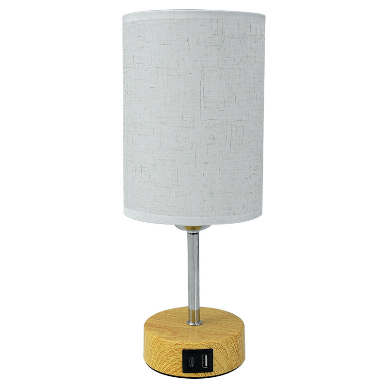 Table lamp with wooden base and gray fabric shade on a white background