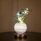 Decorative lamp with glowing flowers in a marble-like vase on a dark surface.