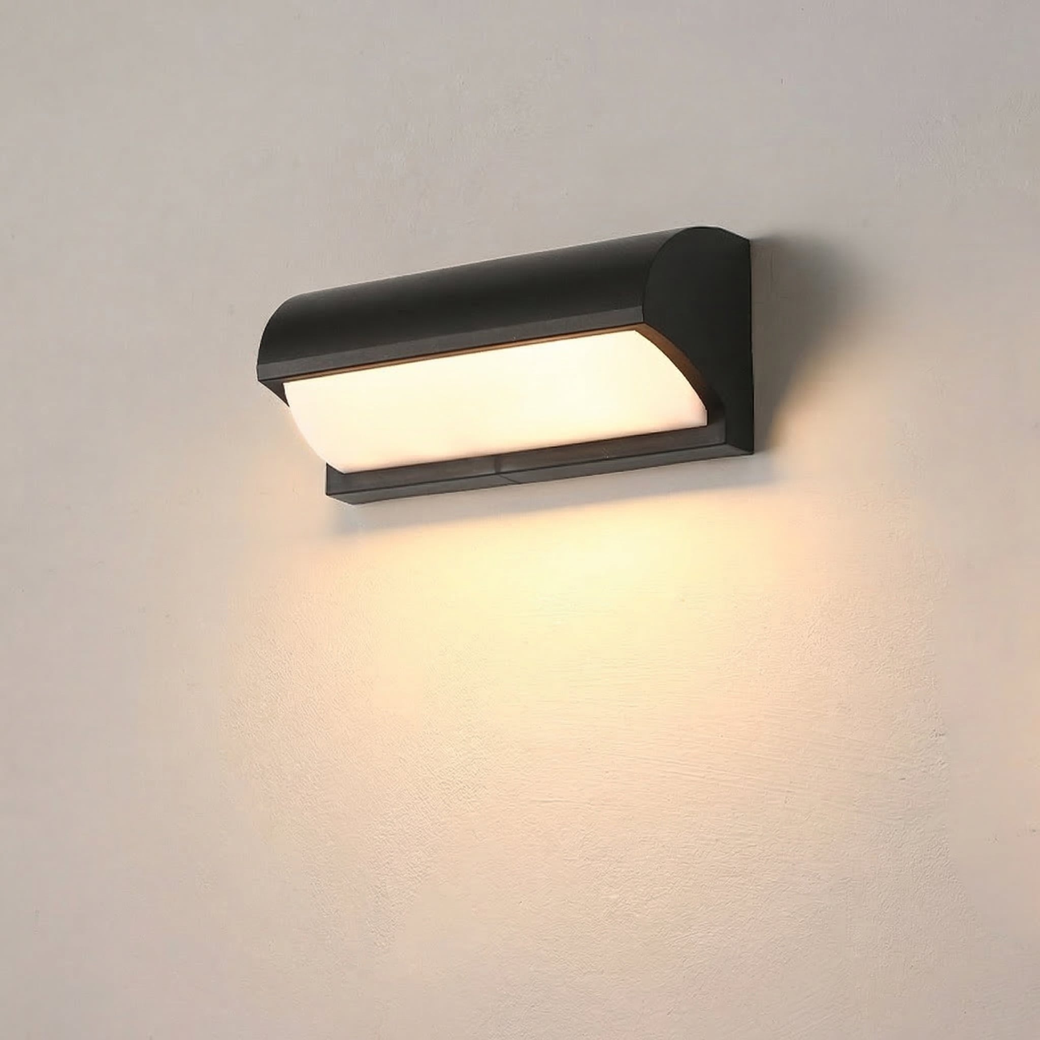 Black wall-mounted outdoor light fixture on a gray wall