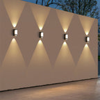 Geometric wall lights on a decorative wall with a geometric pattern.