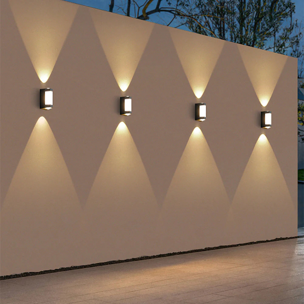 Geometric wall lights on a decorative wall with a geometric pattern.