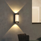 Modern wall-mounted light fixture on a concrete wall with a chair in the foreground.
