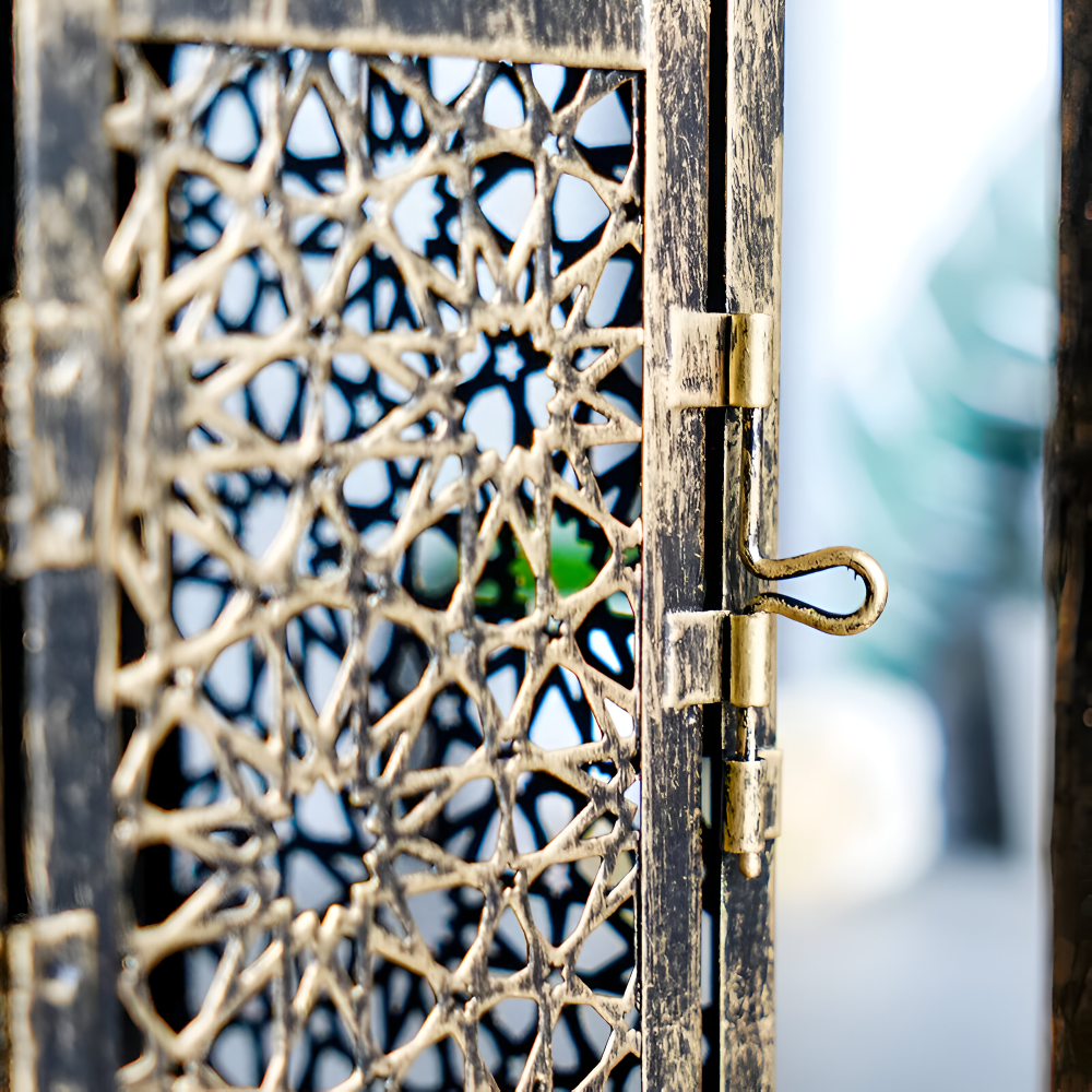 Decorative metal gate with intricate patterns and a blurred background