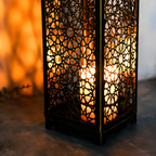 Decorative lantern with intricate patterns and warm light on a blurred background