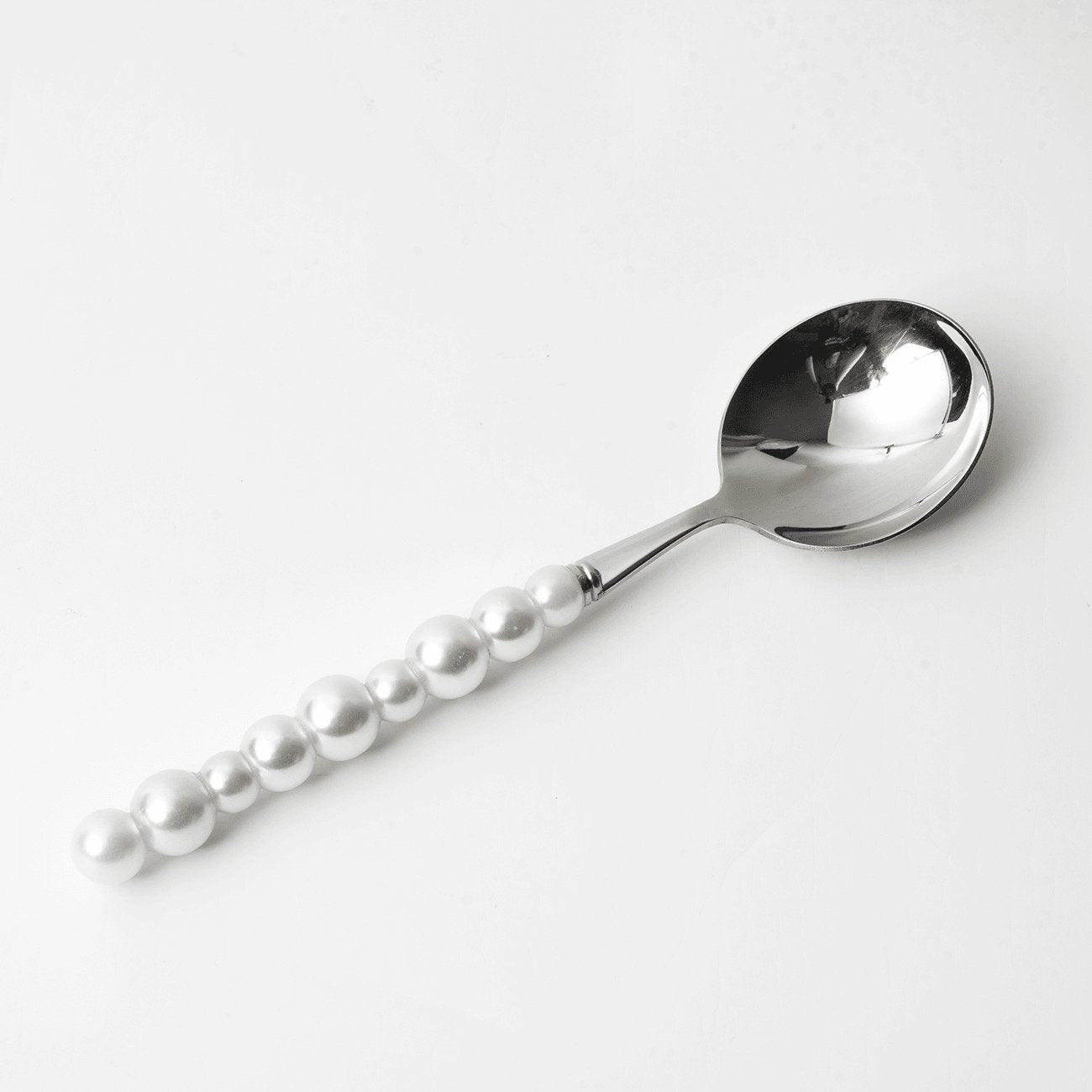 Spoon with pearl-like beads on a white background