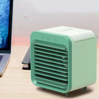 Green portable air conditioner on a desk next to a laptop
