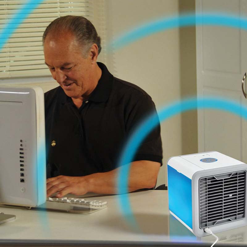 Man using a computer with a small air conditioner on the desk