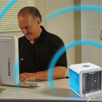 Man using a computer with a small air conditioner on the desk