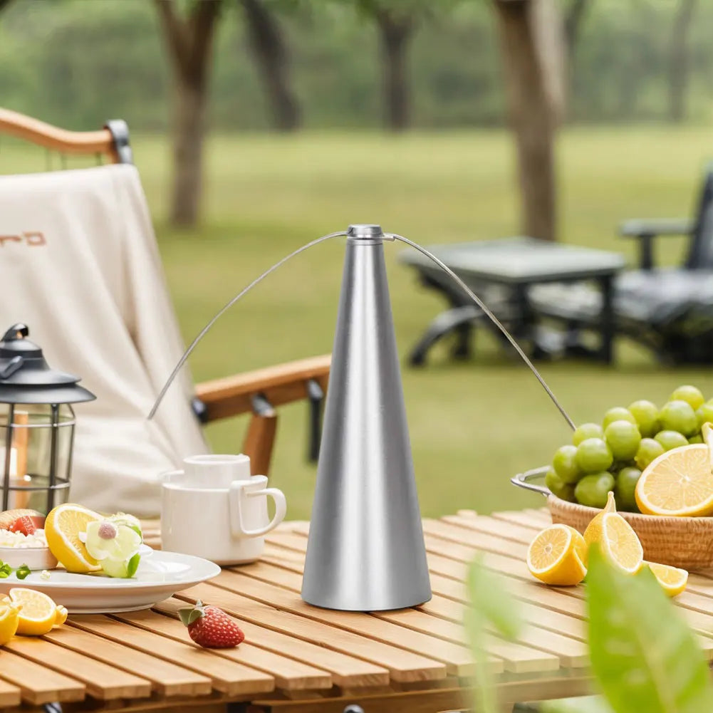 Outdoor setting with a metal lamp on a wooden table, surrounded by fruits and a chair.