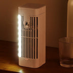 Small beige fan on a wooden surface with a glass container next to it.
