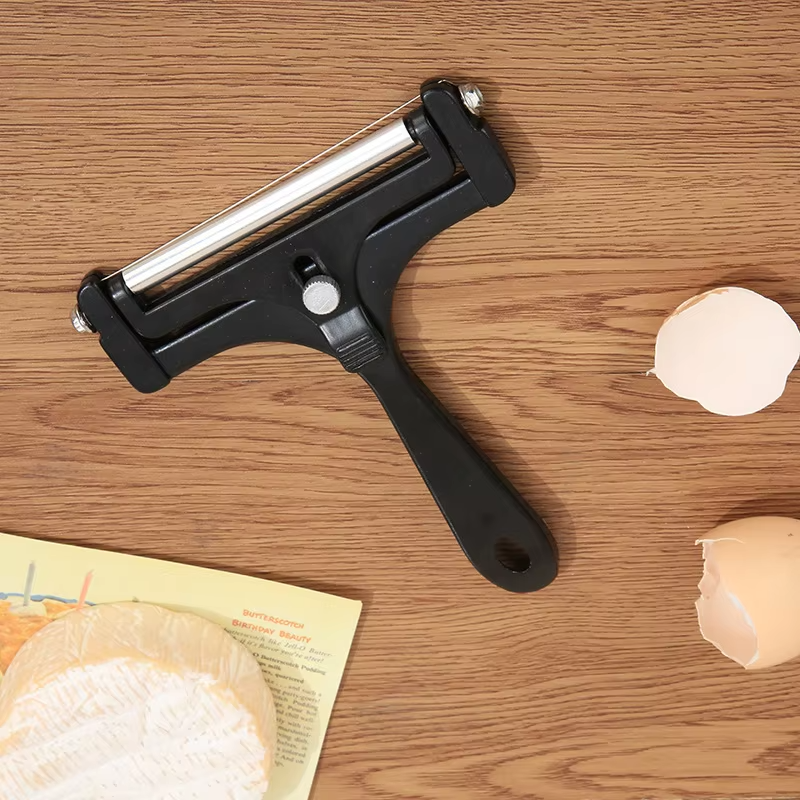 Peelers on a wooden surface with onion peels and a leaflet.