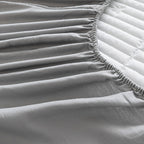 Close-up of a fitted sheet on a bed with a textured surface.