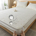 Mattress cover on a bed with a hand holding it, in a bedroom setting.