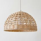 Woven rattan pendant light on a plain background