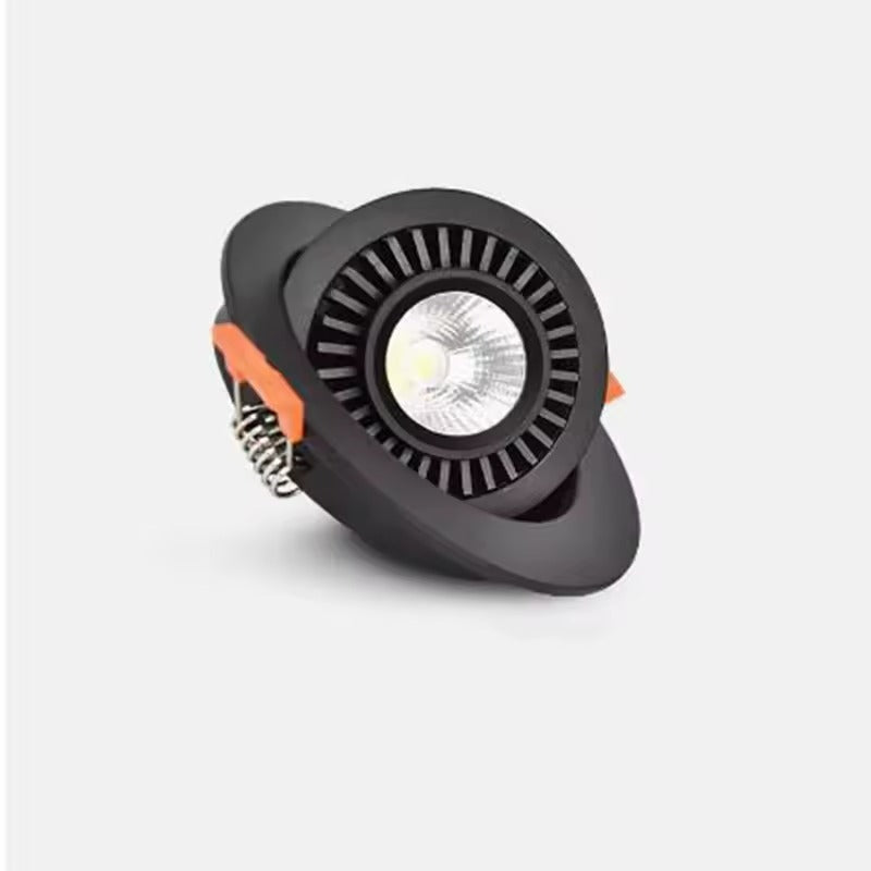 A modern black LED downlight spotlight with a circular ribbed housing, a clear lens, and orange accent details on the side, shown against a light gray background.