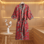 Red and green patterned robe hanging in a sauna with a small table and decorative items.