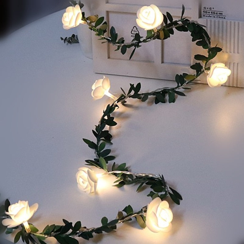 Decorative string lights shaped like roses on a white surface.
