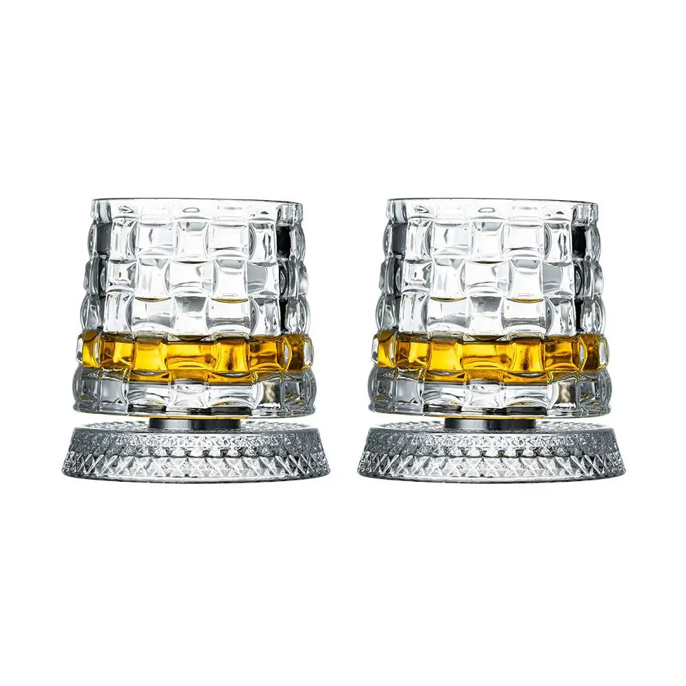 Two crystal glasses with diamond pattern filled with amber liquid on a white background