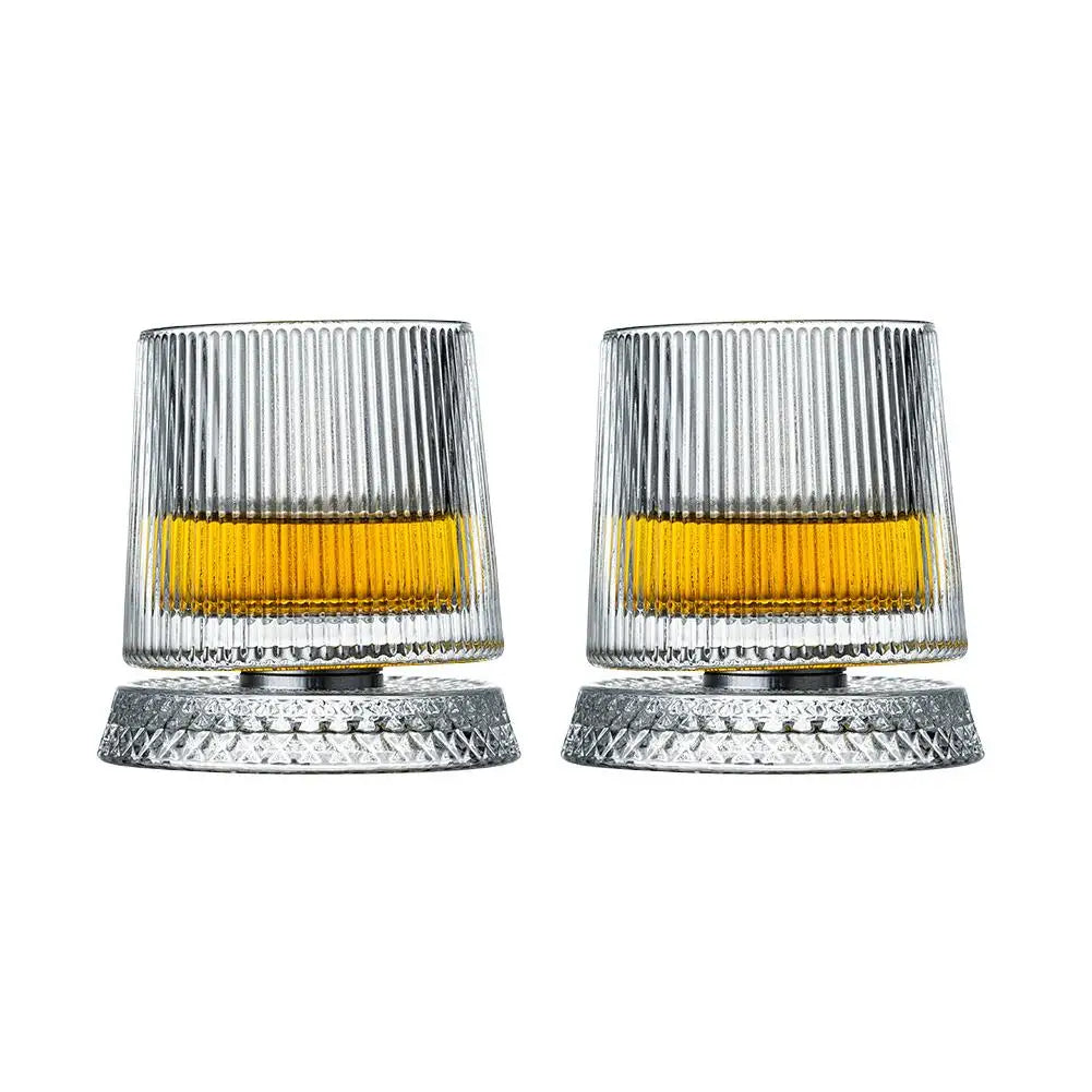 Two clear glass tumblers with yellow liquid on a white background