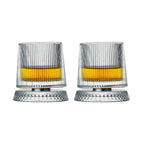 Two clear glass tumblers with yellow liquid on a white background