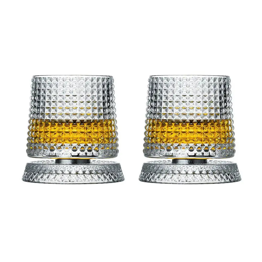 Two crystal glasses with textured design filled with a yellow liquid on a white background