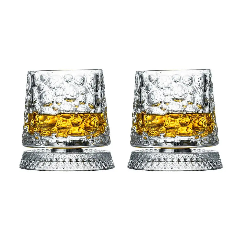Two crystal glasses filled with a yellow liquid on a white background
