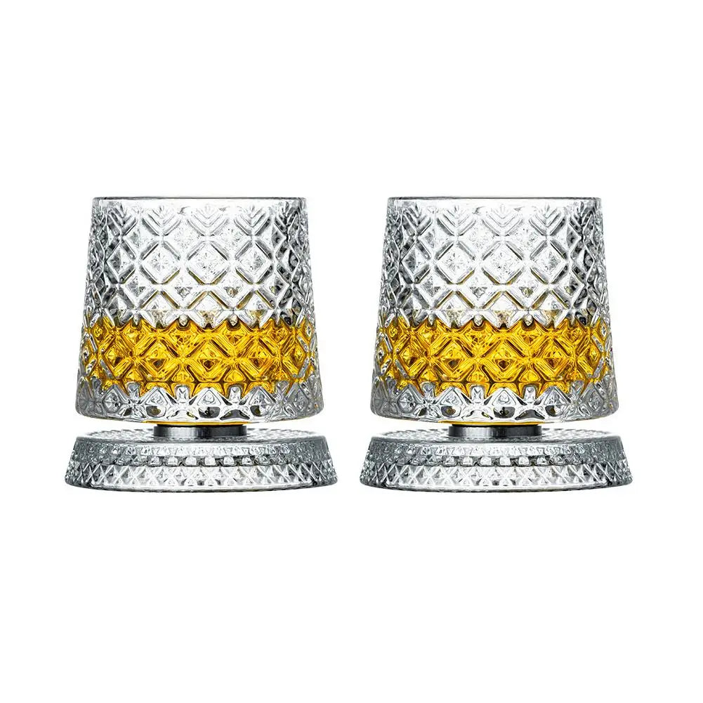 Two crystal glasses with diamond pattern filled with a yellow liquid on a white background