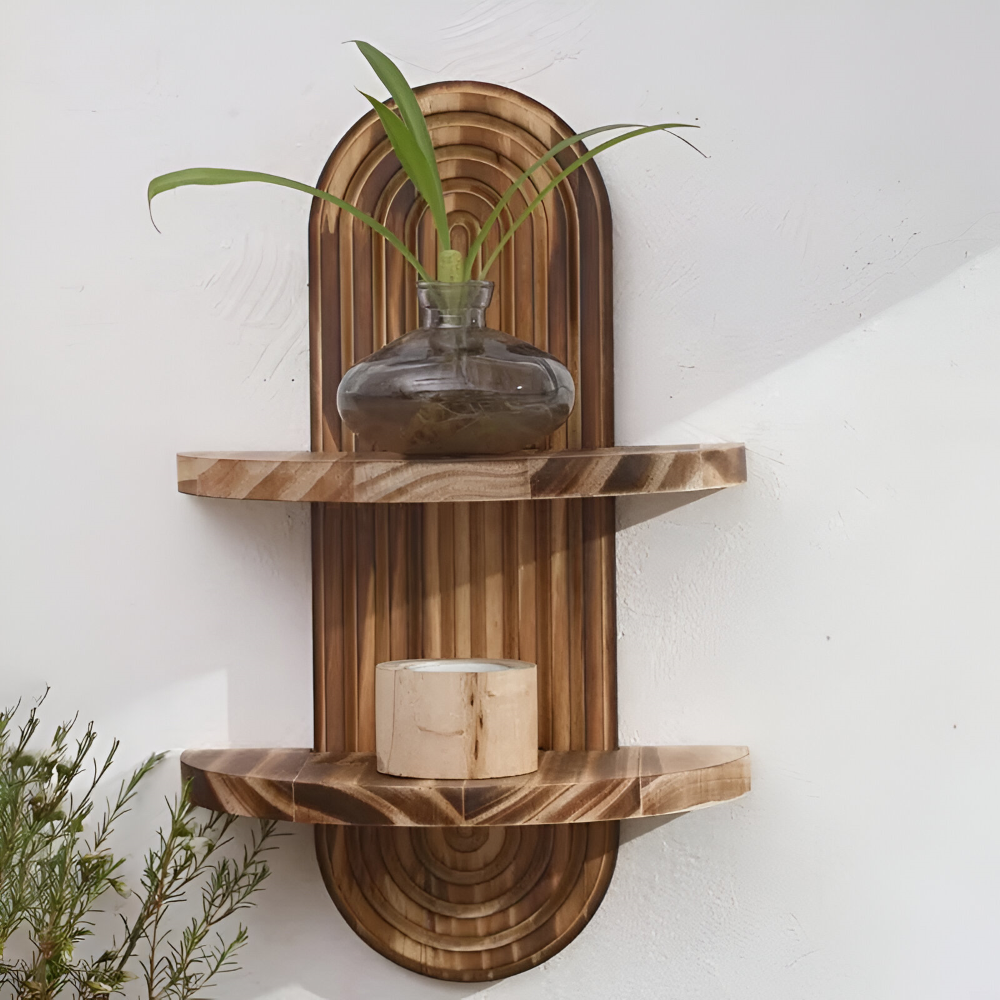 Wooden wall shelf with two shelves, one holding a clear vase with green plant, the other a wooden candle, against a white wall.