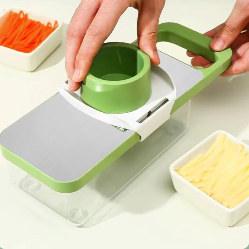 Green and white kitchen slicer with carrots and cheese on a light background