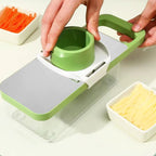 Green and white kitchen slicer with carrots and cheese on a light background