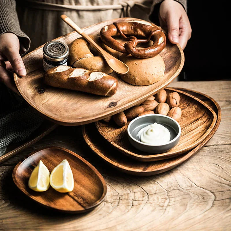 Wooden platters with bread, butter, and lemon wedges on a wooden surface.