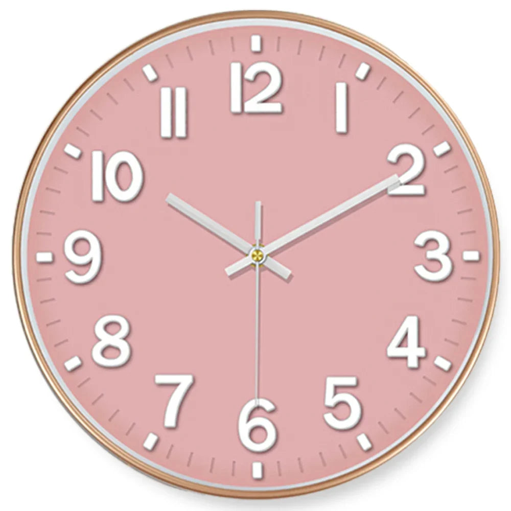 Round wall clock with a pink face and gold frame on a white background