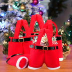 Red Santa suit with black belt and white cuffs on a wooden surface with Christmas decorations in the background.