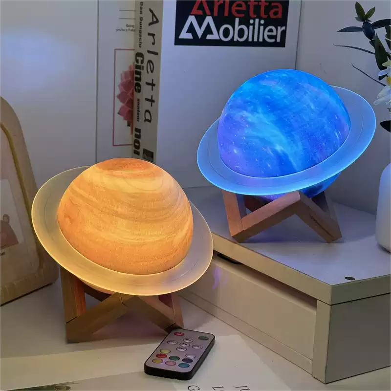 Two spherical lamps, one orange and one blue, on a shelf with a remote control in front.