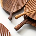 Wooden leaf-shaped cutting boards with handles on a white background