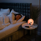 Woman sleeping in bed with a night light on a bedside table next to her.
