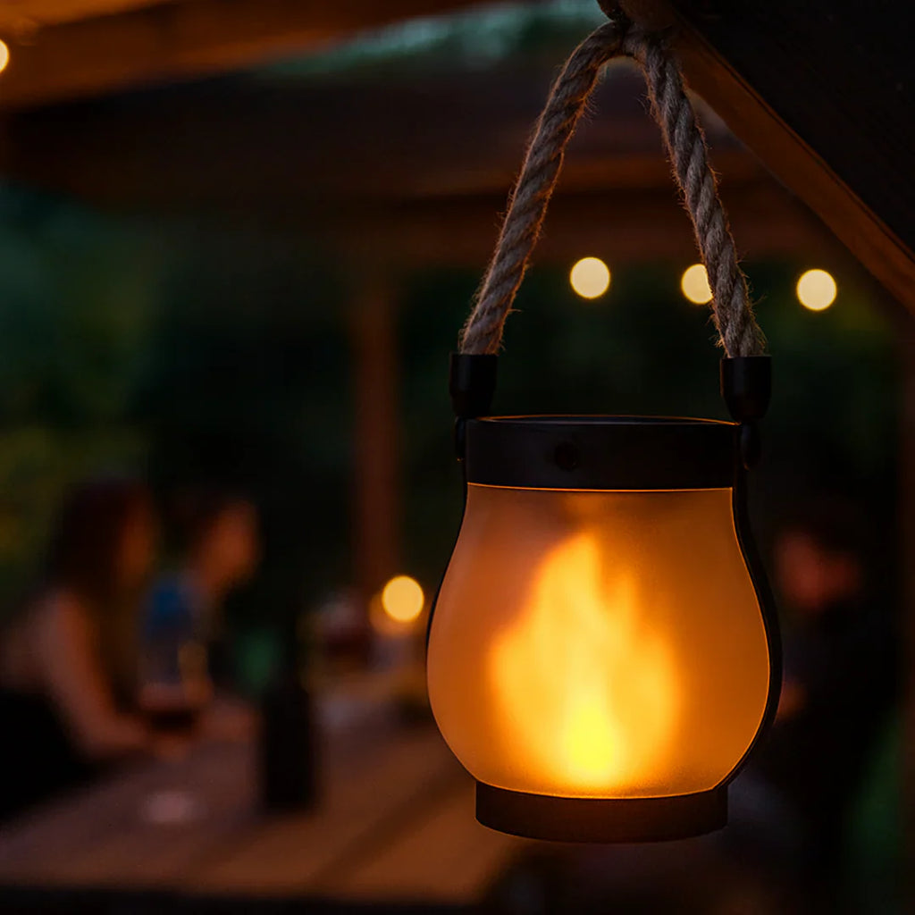 Hanging lantern emitting a warm glow with blurred outdoor background