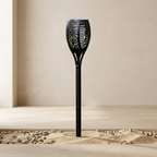 Black decorative garden torch on sand with a neutral background