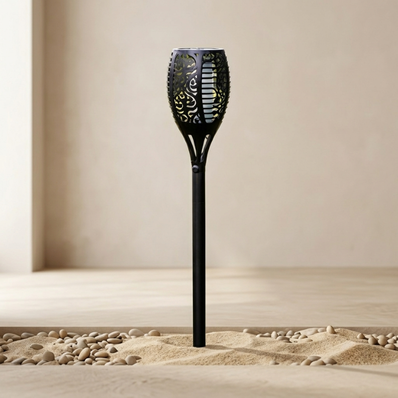 Black decorative garden torch on sand with a neutral background