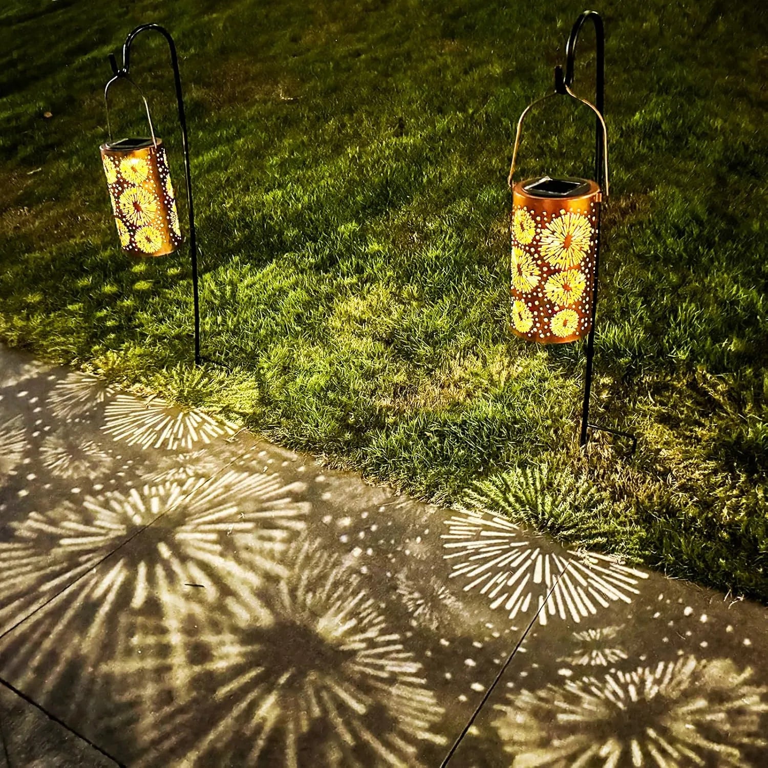 Solar-powered garden lanterns casting decorative shadows on a pavement.