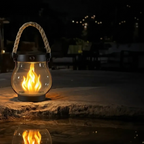 Glass lantern with flame on a stone surface at night