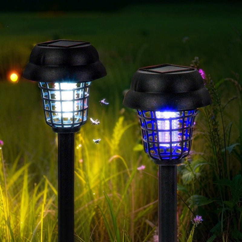 Two solar-powered outdoor lights with bug zappers in a grassy area.